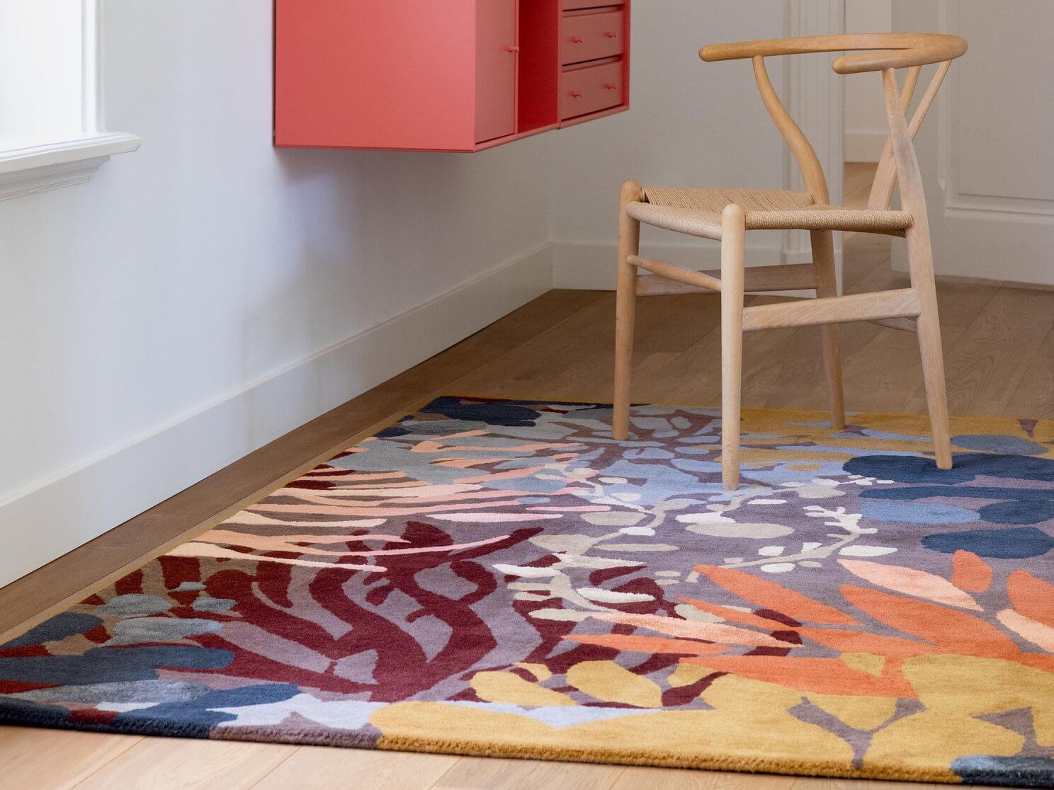 Alfombra Estella Submarine de Brink & Campman en dos colores: una con tonalidades cálidas como el naranja y marrón, y otra con tonos frescos como azul, verde y amarillo. Patrón inspirado en la vida marina.