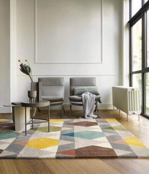 Alfombra Estella Vases de Brink & Campman con un diseño geométrico en colores suaves y vibrantes como azul, verde, amarillo y marrón, hecha de lana pura.